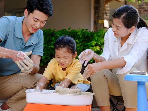 Happy family of three doing pottery together outdoors — Stock Photo, Image