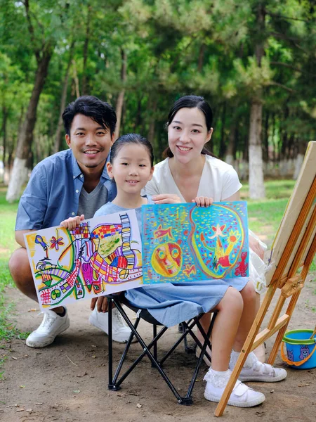 Uma família feliz de três pintura ao ar livre — Fotografia de Stock