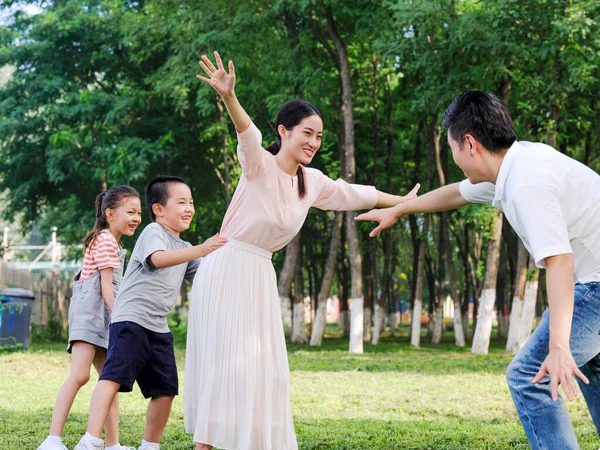 Família feliz de quatro brincando no parque — Fotografia de Stock