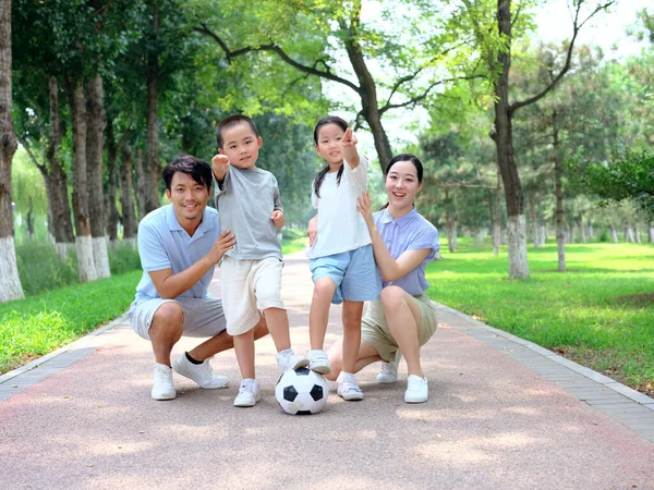 快乐的四口之家在公园踢足球 — 图库照片