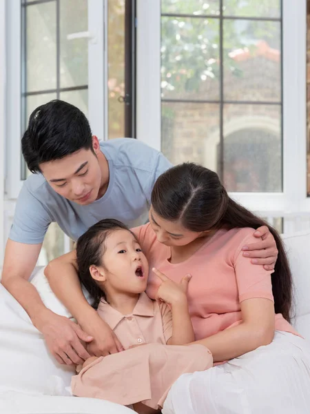 Eine glückliche dreiköpfige Familie sitzt auf dem Sofa im Wohnzimmer — Stockfoto