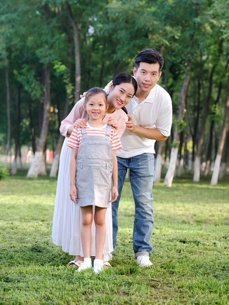 Счастливая семья из трех человек играет в парке — стоковое фото