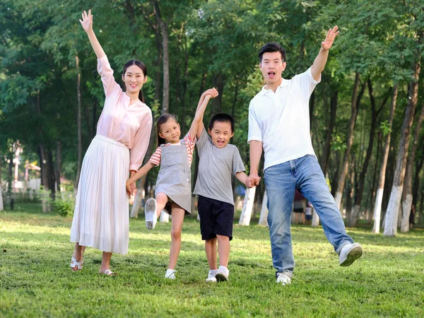 Família feliz de quatro brincando no parque — Fotografia de Stock