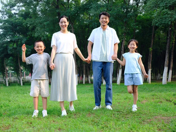 Happy family of four playing in the park — Stock Photo, Image