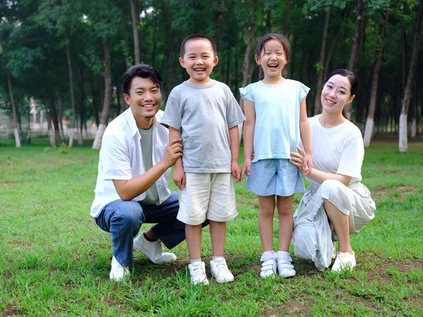 Happy family of four playing in the park — Stock Photo, Image