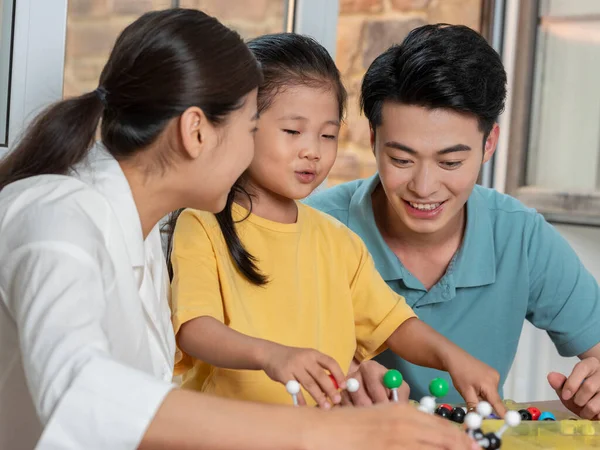 Família feliz de três fazendo modelo de estrutura molecular juntos — Fotografia de Stock