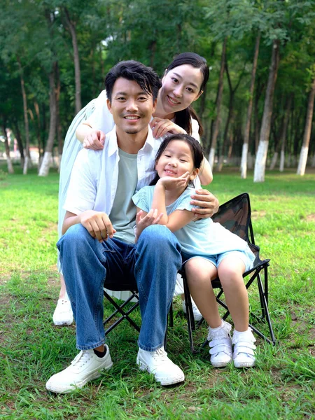 Família feliz de três brincando no parque — Fotografia de Stock