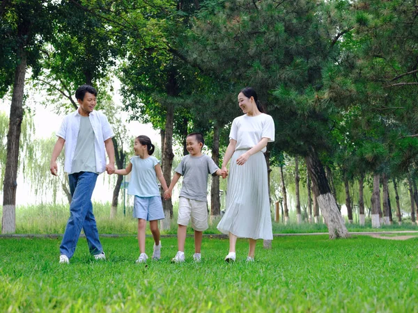 Šťastná čtyřčlenná rodina si hraje v parku — Stock fotografie