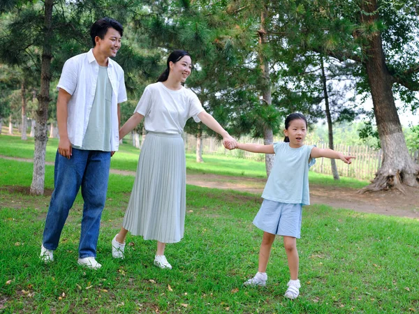 Üç kişilik mutlu bir aile parkta oynuyor. — Stok fotoğraf