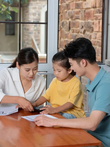 Eine glückliche dreiköpfige Familie mit Taschenrechner — Stockfoto