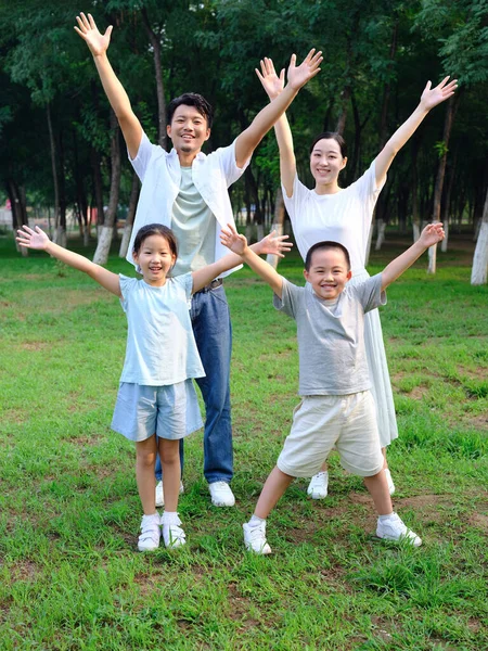 Família feliz de quatro brincando no parque — Fotografia de Stock