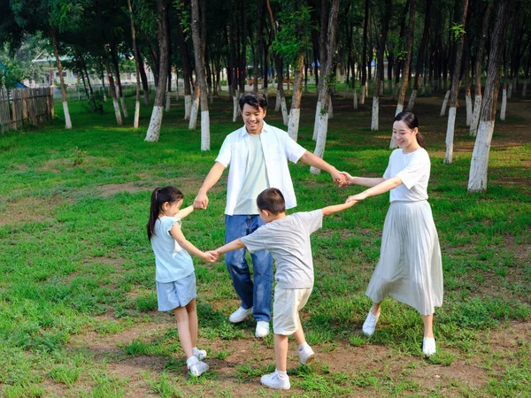 Szczęśliwa czteroosobowa rodzina bawiąca się w parku — Zdjęcie stockowe