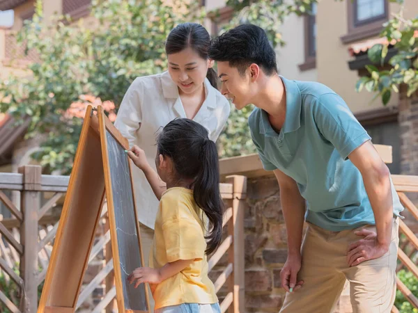 A Happy family of three painting outdoors — Stock Photo, Image