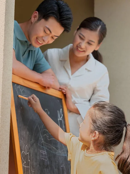 Eine glückliche dreiköpfige Familie malt draußen — Stockfoto