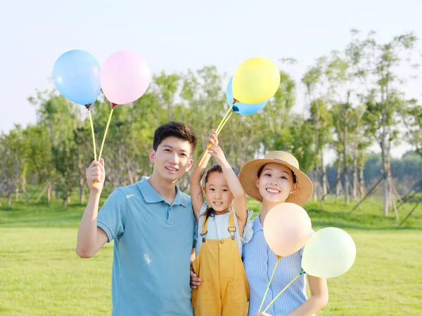 Szczęśliwa trzyosobowa rodzina w parku — Zdjęcie stockowe