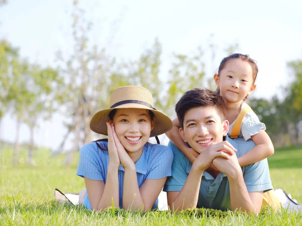 Heureuse famille de trois sur l'herbe — Photo