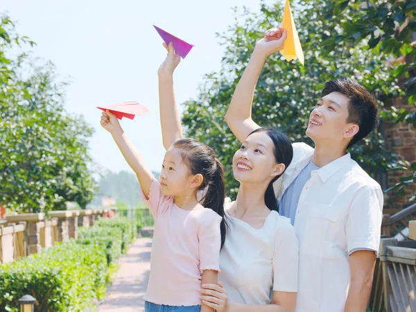 Una famiglia felice di tre aerei che lanciano carta all'aperto — Foto Stock