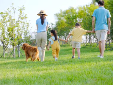 Parkta dört köpekli mutlu bir aile.