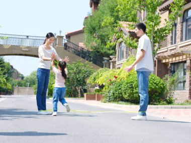 Dışarıda ip atlayan mutlu bir aile.