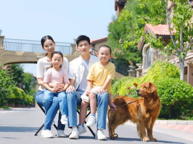 Dört kişilik mutlu bir aile ve açık hava fotoğrafında evcil bir köpek.