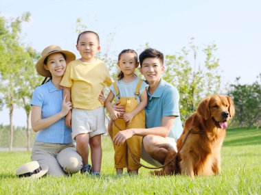 Dört kişilik mutlu bir aile ve açık hava fotoğrafında evcil bir köpek.