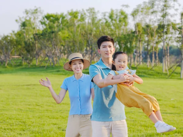 Щаслива сім'я з трьох грає в парку — стокове фото