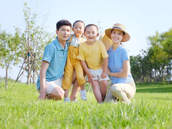 Família feliz de quatro na foto do grupo ao ar livre — Fotografia de Stock