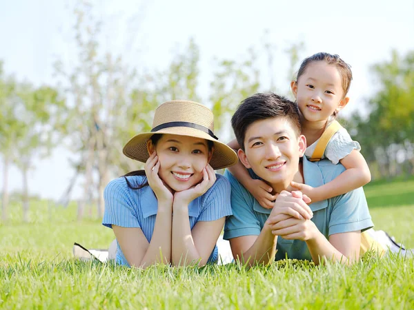 Щаслива сім'я з трьох на траві — стокове фото