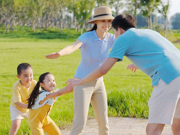 Gelukkige familie van vier spelen games in het park — Stockfoto