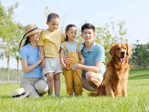 Família feliz de quatro e cão de estimação na foto ao ar livre — Fotografia de Stock