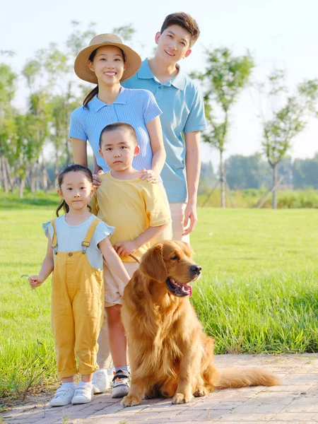 Família feliz de quatro e cão de estimação no parque — Fotografia de Stock