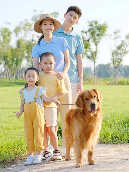 Família feliz de quatro e cão de estimação no parque — Fotografia de Stock