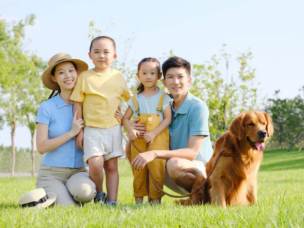 Familia feliz de cuatro y perro mascota en la foto al aire libre —  Fotos de Stock