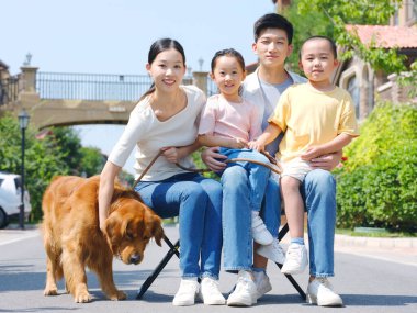 Dört kişilik mutlu bir aile ve açık hava fotoğrafında evcil bir köpek.