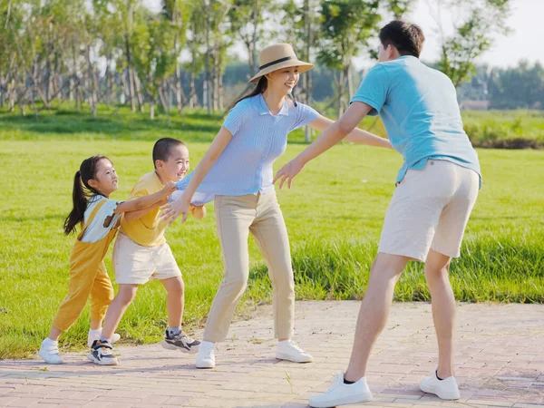 Gelukkige familie van vier spelen games in het park — Stockfoto