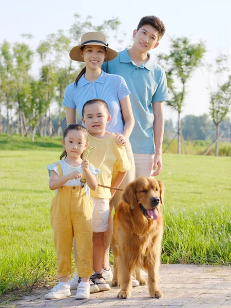 Χαρούμενη τετραμελής οικογένεια και σκύλος συντροφιάς στο πάρκο — Φωτογραφία Αρχείου