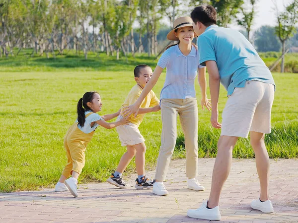 Familia feliz de cuatro juegos en el parque — Foto de Stock