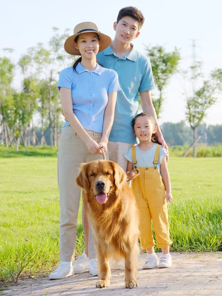 Joyeux famille de trois et chien de compagnie dans le parc — Photo