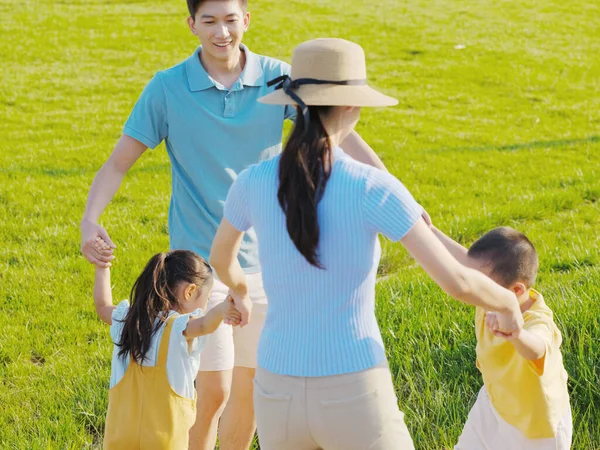 Щаслива сім'я з чотирьох грає в парку — стокове фото