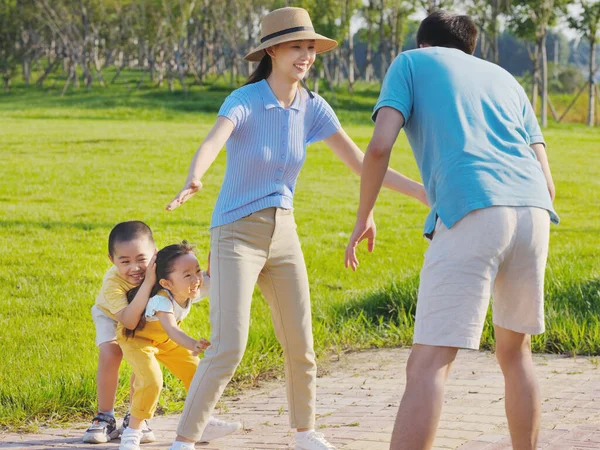 Familia feliz de cuatro juegos en el parque —  Fotos de Stock