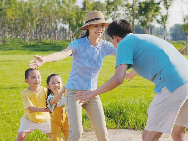 Счастливая семья из четырех человек играет в парк — стоковое фото