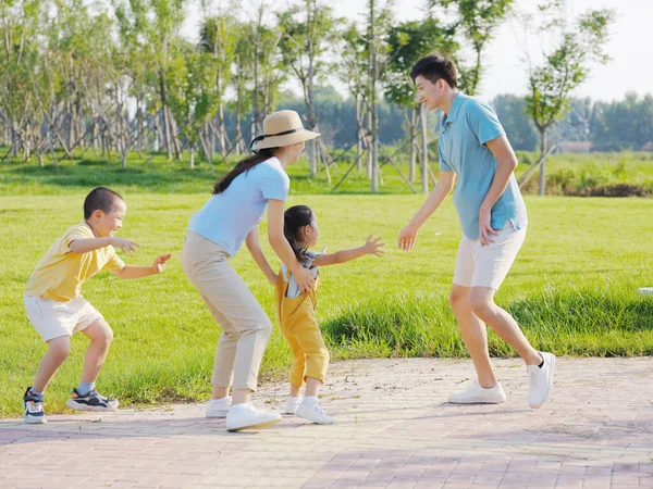 Família feliz de quatro jogos no parque — Fotografia de Stock