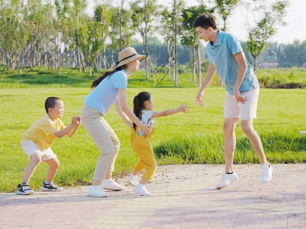 Família feliz de quatro jogos no parque — Fotografia de Stock