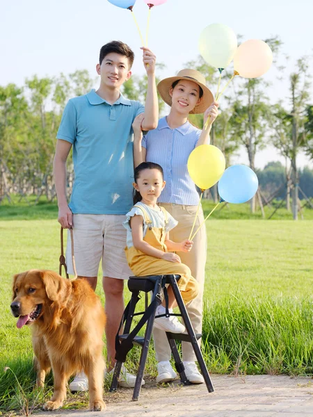 Joyeux famille de trois et chien de compagnie dans le parc — Photo