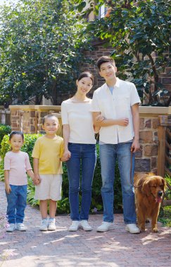 Dört kişilik mutlu bir aile ve açık hava fotoğrafında evcil bir köpek.