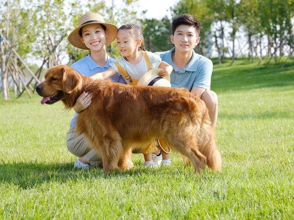 Família feliz de três e cão de estimação na foto ao ar livre — Fotografia de Stock