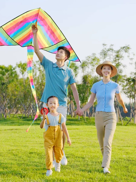 Ευτυχισμένη οικογένεια τριών ιπτάμενων χαρταετών στο πάρκο — Φωτογραφία Αρχείου