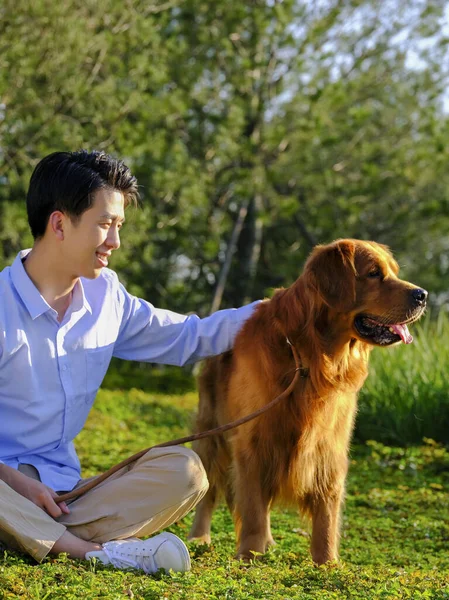Ένας άντρας με ένα σκυλάκι στο πάρκο. — Φωτογραφία Αρχείου