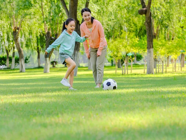 快乐的妈妈和女儿在公园踢足球 — 图库照片