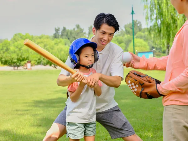 Gelukkig gezin van drie honkbal spelend in het park — Stockfoto